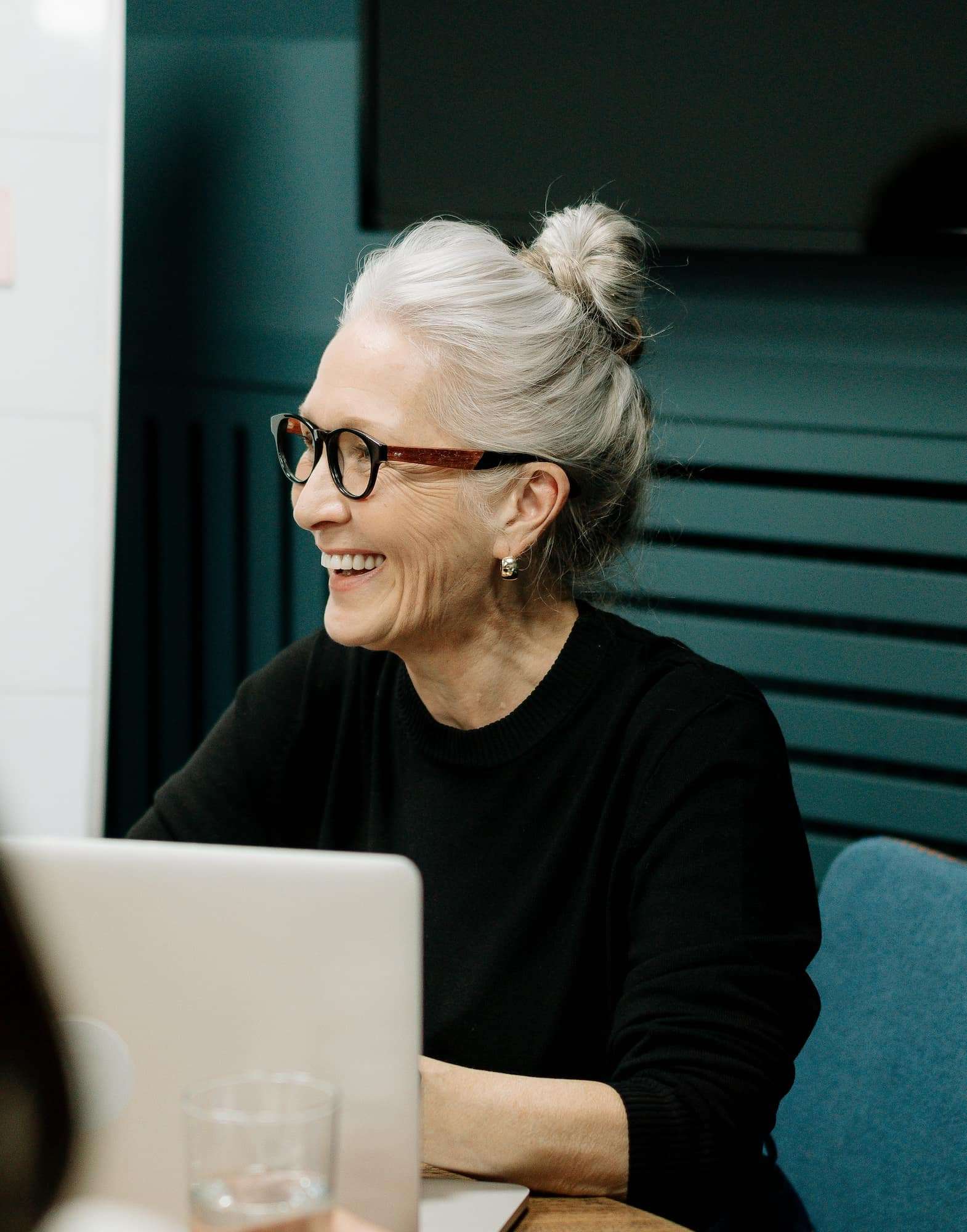 Femme senior devant un ordinateur avec un grand sourire